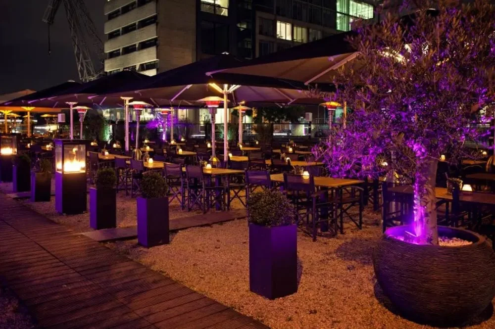 Restaurantterrasse mit beleuchteten Bäumen am Abend